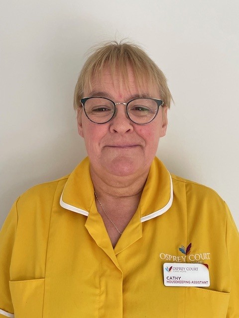 lady in yellow top wearing glasses smiling at camera