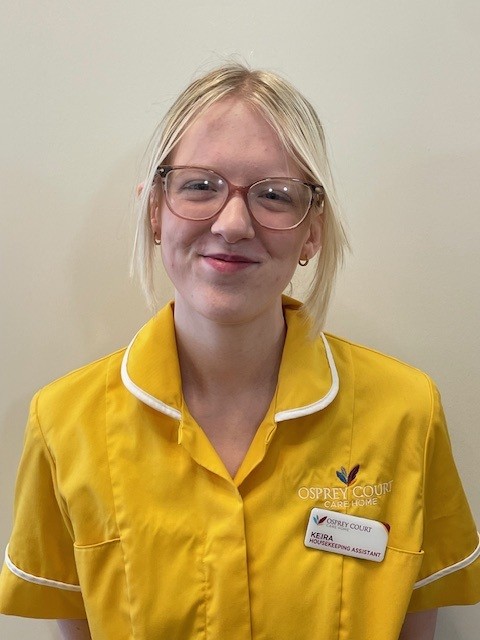 lady in yellow top and glasses smiling at camera