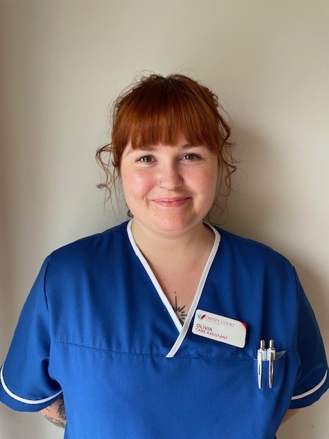 lady in blue top smiling at camera