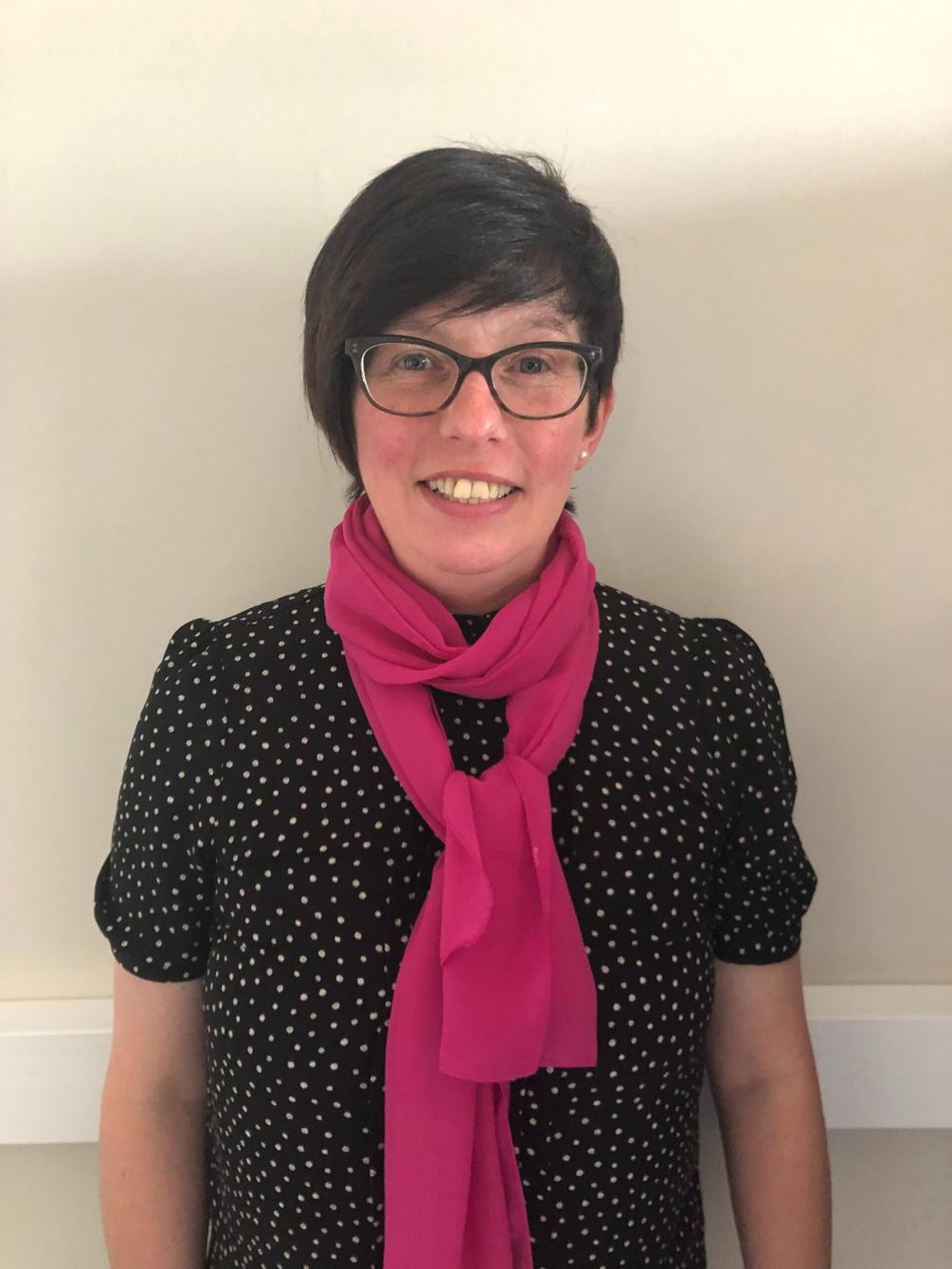 lady with glasses posing for staff photo