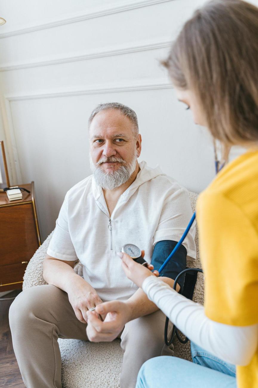 older man getting blood pressure taken by nurse