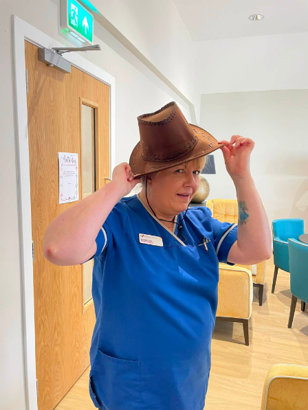 staff posing in the west hoedown event with the hat
