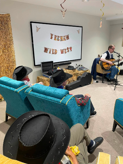 man singing in front of the residents at the west hoedown event
